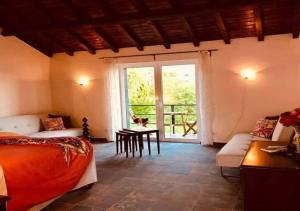 ein Schlafzimmer mit einem Bett, einem Sofa und einem Fenster in der Unterkunft BBmontejunto in Cadaval