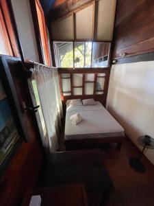 a small room with two beds and a window at Perla Negra Beachfront in Puerto Viejo