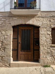 a wooden door on a stone building with a balcony at Casa Valleta in Tivenys