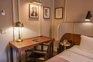 a bedroom with a bed and a desk with a lamp at The Evelyn NoMad in New York