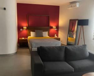 グアダラハラにあるHotel Boutique Abadのベッドとソファ付きのホテルルーム