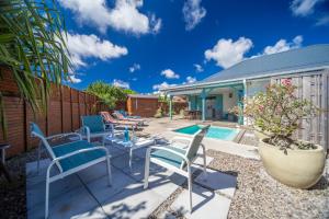 un patio con sillas y una piscina en Douceur Créole, en Sainte-Luce