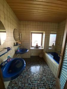 ein Badezimmer mit zwei Waschbecken, einer Badewanne und zwei Fenstern in der Unterkunft Ferienwohnung Bergliebe in Staudach-Egerndach