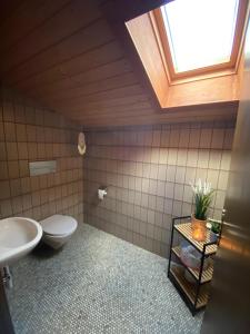 ein Bad mit einem WC, einem Waschbecken und einem Fenster in der Unterkunft Ferienwohnung Bergliebe in Staudach-Egerndach