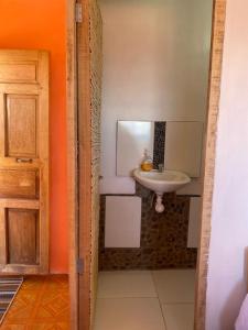 La salle de bains est pourvue d'un lavabo, d'un miroir et d'une porte. dans l'établissement Orlando´s House, à Ocosuyo