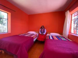 a woman sitting in a room with two beds at Orlando´s House in Ocosuyo