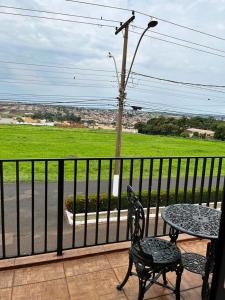 a balcony with a table and chairs and a view of a street at Hotel São Marcos in Orlândia