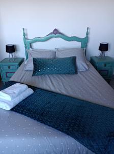 1 cama con 2 mesitas de noche azules y 2 lámparas en Fraga`s House - Douro e Natureza en Coura