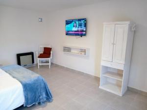 a bedroom with a bed and a tv on the wall at Cabañas Aluen in El Calafate