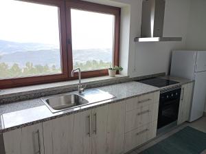cocina con fregadero y ventana grande en Fraga`s House - Douro e Natureza, en Coura