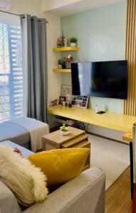 sala de estar con sofá y TV de pantalla plana en The Loop 1-Bedroom sleeps 6, near Limketkai mall in Cagayan de Oro, en Cagayan de Oro