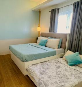 1 dormitorio con 2 camas y ventana en The Loop 1-Bedroom sleeps 6, near Limketkai mall in Cagayan de Oro, en Cagayan de Oro