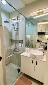 y baño con ducha acristalada y lavamanos. en The Loop 1-Bedroom sleeps 6, near Limketkai mall in Cagayan de Oro, en Cagayan de Oro