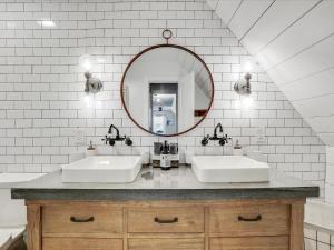 La salle de bains est pourvue de 2 lavabos et d'un miroir. dans l'établissement Scenic Rustic Farmhouse - Patio Gameroom Firepit, à Garland