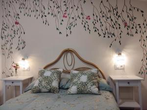 1 dormitorio con 1 cama con flores en la pared en Alange Termal, en Alange