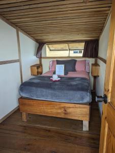 a bed in a room with a wooden ceiling at Barrbra BnB Over The Sea in Bocas del Toro