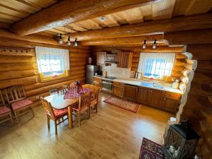a kitchen with a table and chairs in a cabin at Drevenica Donovaly in Donovaly