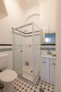 a white bathroom with a shower and a toilet at Surry Hills Chic right on Crown St in Sydney