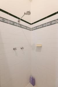 a bathroom with a shower with white tiles at Surry Hills Chic right on Crown St in Sydney