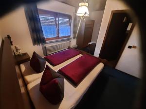 ein Schlafzimmer mit einem großen Bett mit roter Bettwäsche und Kissen in der Unterkunft Gasthof Keller Merdingen in Merdingen