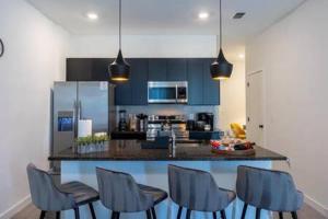 une cuisine avec des armoires bleues et un comptoir avec des chaises dans l'établissement 3308 - Gorgeous 3bed vacation home, à Kissimmee