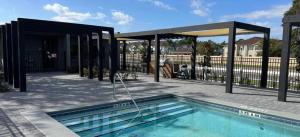 - une piscine avec un pavillon à côté d'une maison dans l'établissement 3308 - Gorgeous 3bed vacation home, à Kissimmee