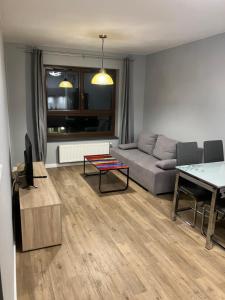 a living room with a couch and a table at Jab Apartment NOWE FORTY Business & Family in Szczecin