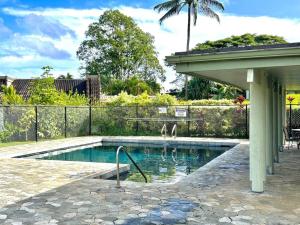 a swimming pool with two dogs standing in the water at Keiki Honu Kauai Princeville 2BR2BA King+Queen bed in Princeville