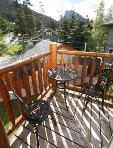 two chairs and a table on a deck at Beaujolais Boutique B&B at Thea's House in Banff