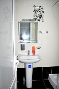bagno con lavandino bianco e specchio di Hotel Okriba a Kutaisi