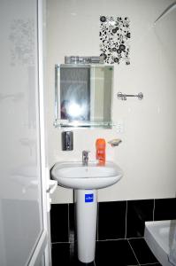 a bathroom with a white sink and a mirror at Hotel Okriba in Kutaisi