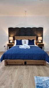 - une chambre avec un lit bleu et 2 tables de nuit dans l'établissement Studio Bleu, à Birmingham