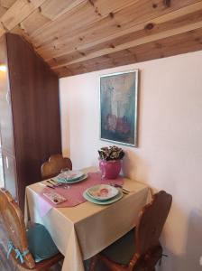 a table with two plates and a vase on it at Cottage Mila in Žabljak