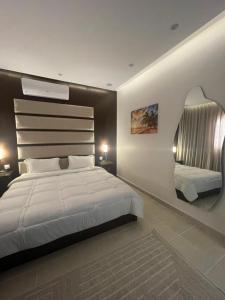 a bedroom with a large white bed and a mirror at استديو فندقي فاخر in Riyadh