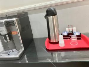 Ein Mixer steht auf einem roten Tablett auf einer Arbeitsfläche. in der Unterkunft Hotel Chantilly in Presidente Prudente