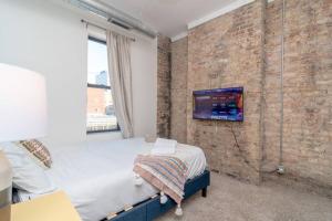 a bedroom with a bed and a brick wall at McCormick Place 3Br and 2Ba with Optional Parking , sleeps 8 in Chicago