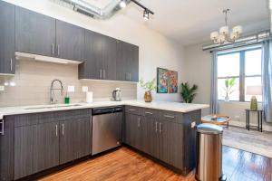 a kitchen with wooden cabinets and a large window at McCormick Place 3Br and 2Ba with Optional Parking , sleeps 8 in Chicago