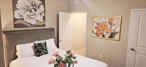 Atlanta Buckhead Style في أتلانتا: غرفة نوم مع سرير مع إناء من الزهور عليه