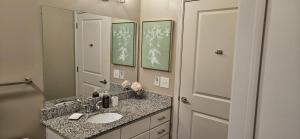 La salle de bains est pourvue d'un lavabo et d'un miroir. dans l'établissement Atlanta Buckhead Style, à Atlanta