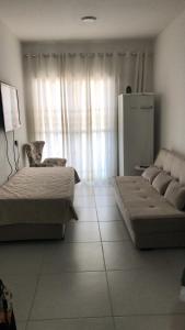 ein Wohnzimmer mit zwei Betten und einer Couch in der Unterkunft Apartamento no Condomínio da Fé in Cachoeira Paulista