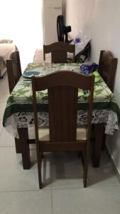 einen Tisch und Stühle mit einem Tisch und einem Telefon darauf in der Unterkunft Apartamento no Condomínio da Fé in Cachoeira Paulista + 1 Foto