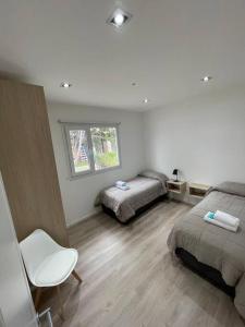 um quarto com 2 camas, uma cadeira e uma janela em Apartament in the center Ushuaia two em Ushuaia