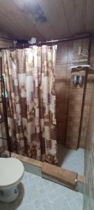 a shower curtain in a bathroom with a toilet at Hugo's Relax Home (Casa) in Ayangue