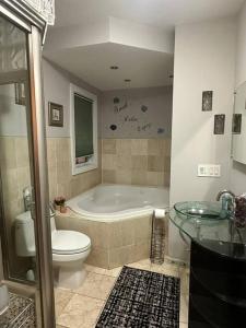 ein Badezimmer mit einer Badewanne, einem WC und einem Waschbecken in der Unterkunft Spacious and Cozy- near T-station-Quiet Neighborhood! in Malden