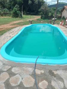 a large blue pool with a hose in a yard at Pousada Paraíso Pedacinho Do Céu 2 in Águas de Lindóia