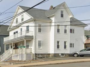 a white house with a car parked in front of it at Spacious and Cozy- near T-station-Quiet Neighborhood! in Malden
