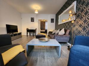een woonkamer met een bank en een tafel bij Goodison Accommodation in Liverpool