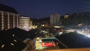 uitzicht op een stad in de nacht met gebouwen bij Apartman DND LUX sa garazom in Zlatibor