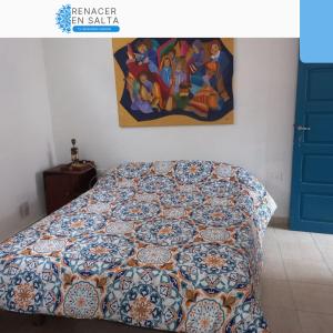 1 cama en un dormitorio con una pintura en la pared en Renacer en Salta en Salta