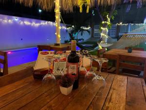 a bottle of wine and wine glasses on a wooden table at Posada chachalacas in Chachalacas